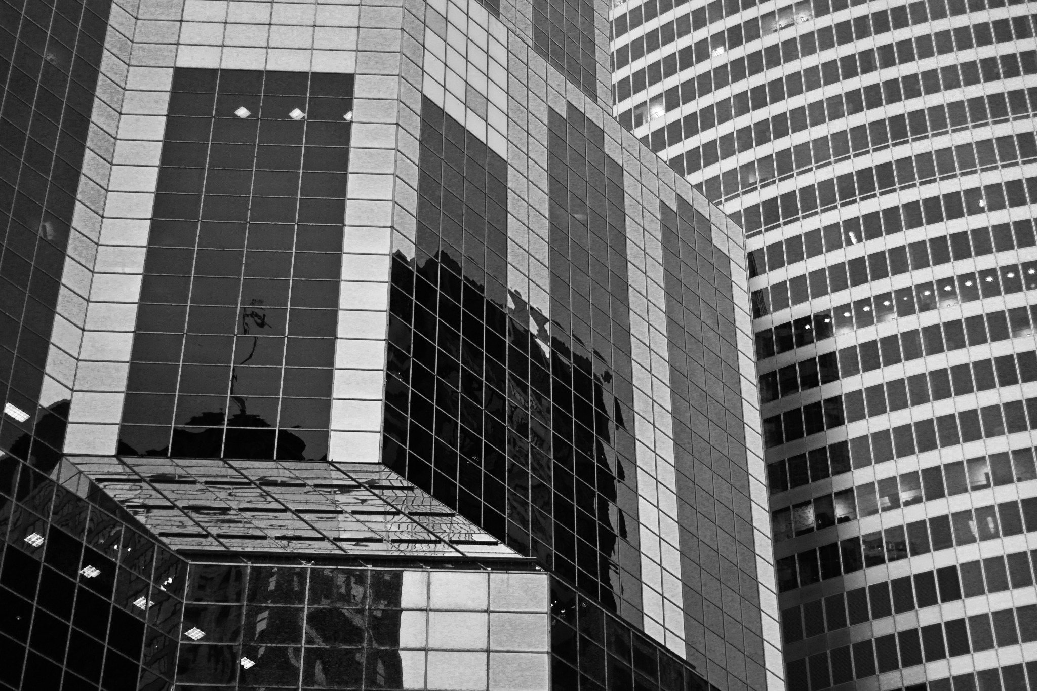 Black-and-white study of reflective office buildings and repeating window grids
