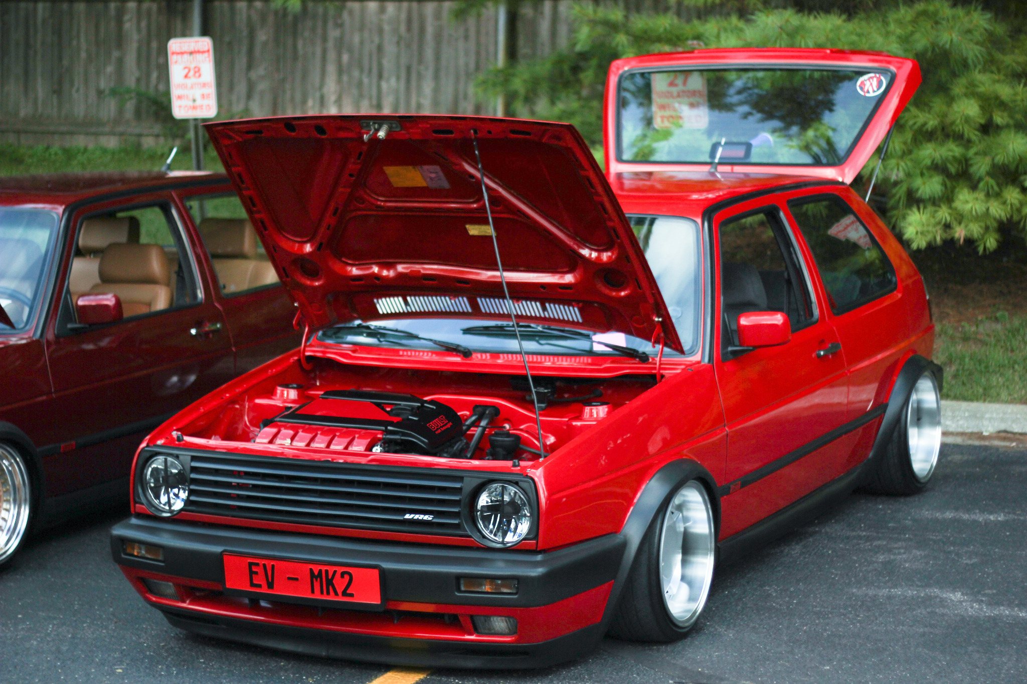 Bright red Volkswagen Golf Mk2 displayed with its hood and hatch open