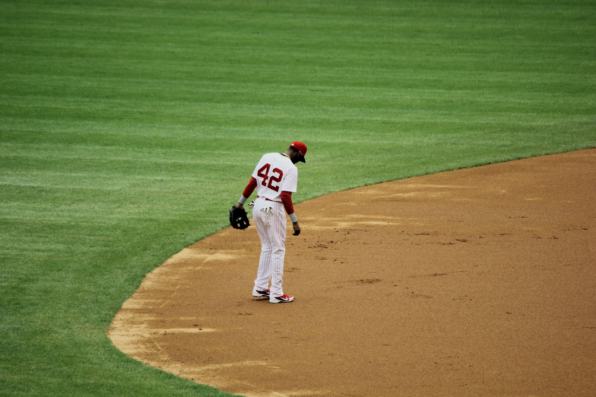Baseball player wearing number 42 standing alone near the mound