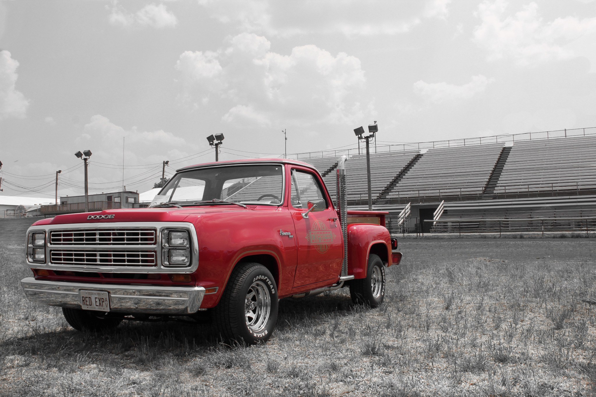 Red vintage Dodge pickup truck photographed near empty grandstands