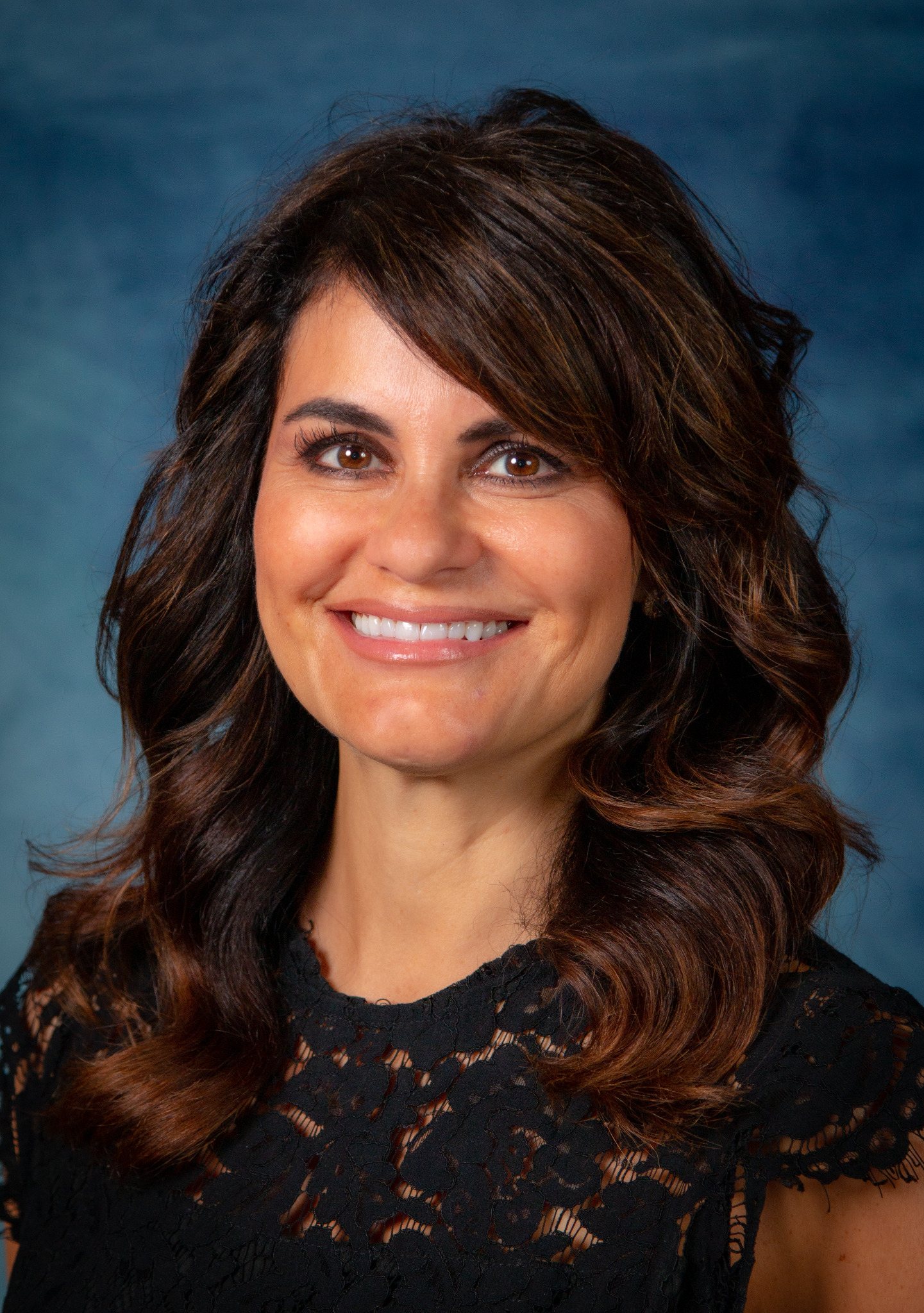Studio headshot of a woman against a blue backdrop
